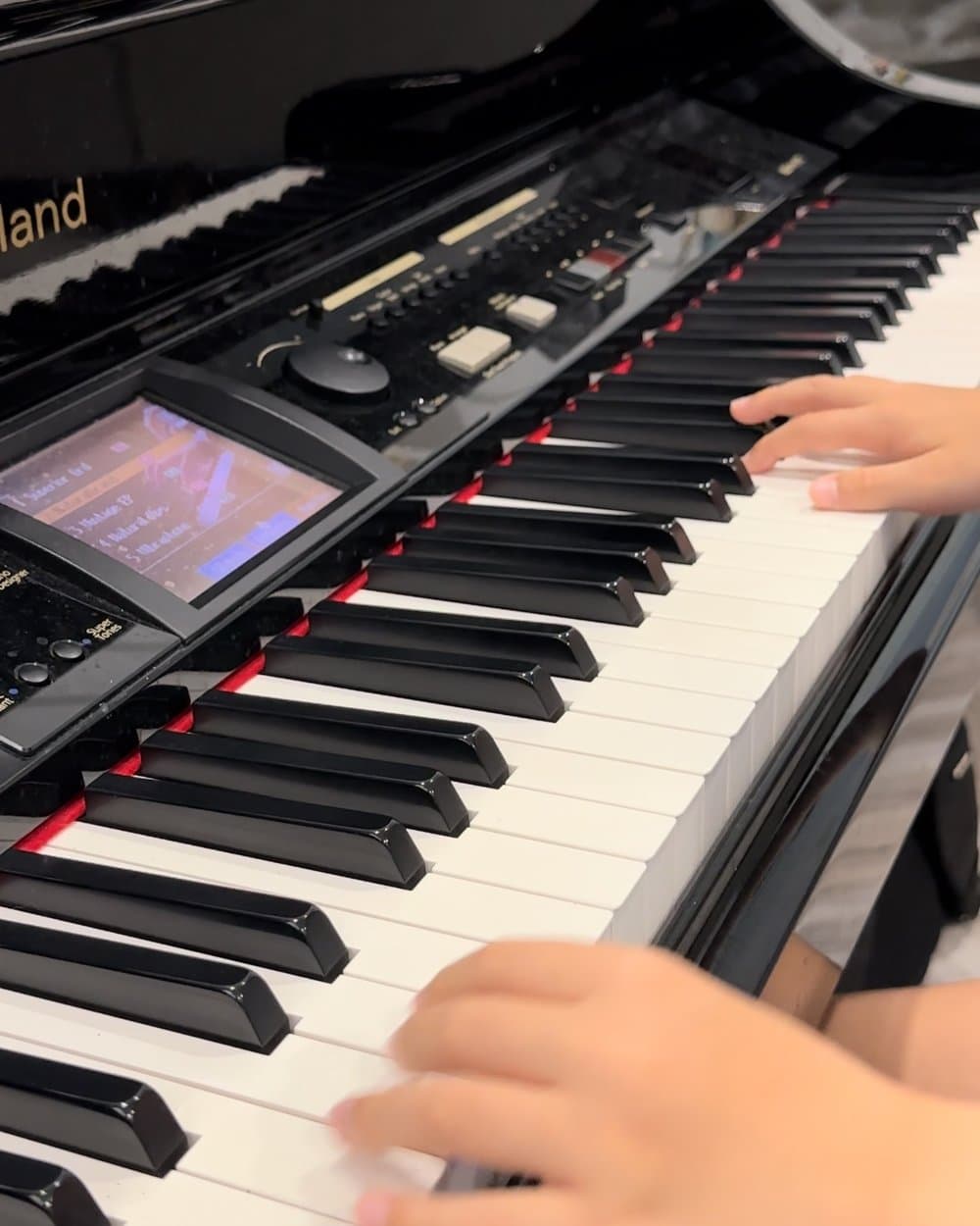 A young child learning piano at home